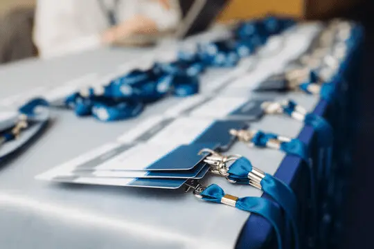 Event registration table with neatly arranged blue lanyards and name badges, ready for attendees.